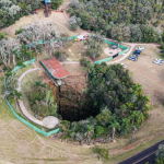 A atração permitirá que os visitantes desçam na caverna vertical por cerca de 54 metros e caminhem por um deck flutuante que fica sobre o lago do fundo da furna.